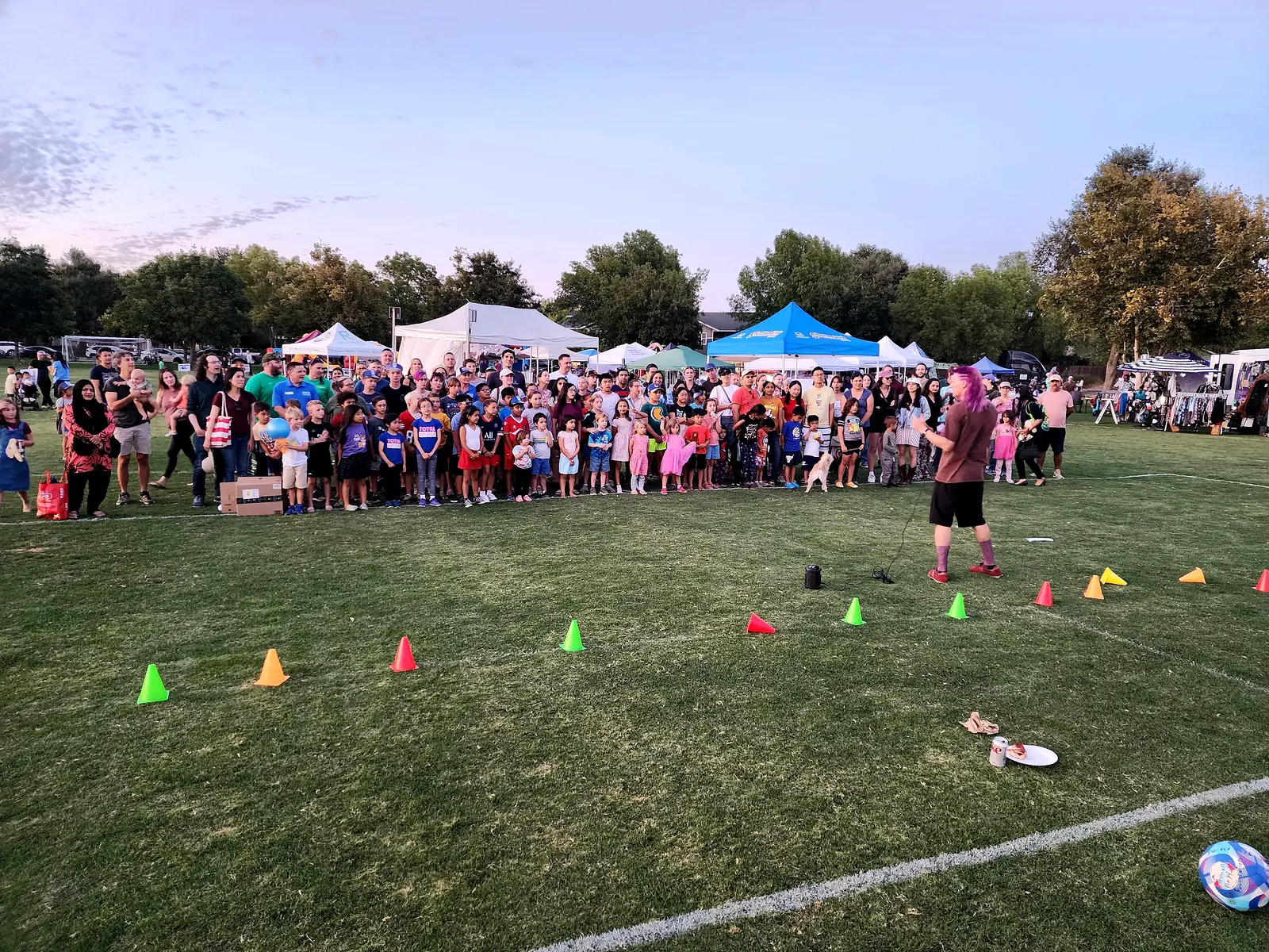 A bright dusk crowd of Davis families gathered on the Community Park lawn at Family Fun Fest
