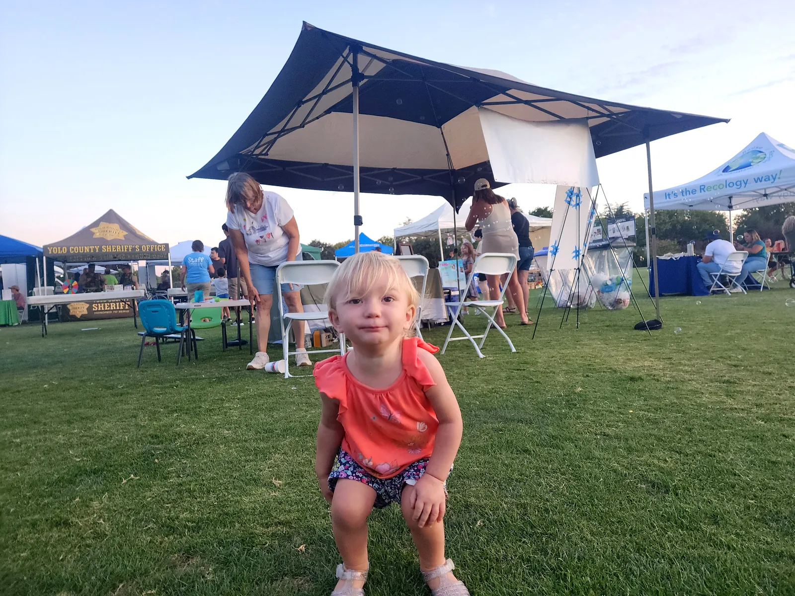 A young child smiles in golden evening light at the festival