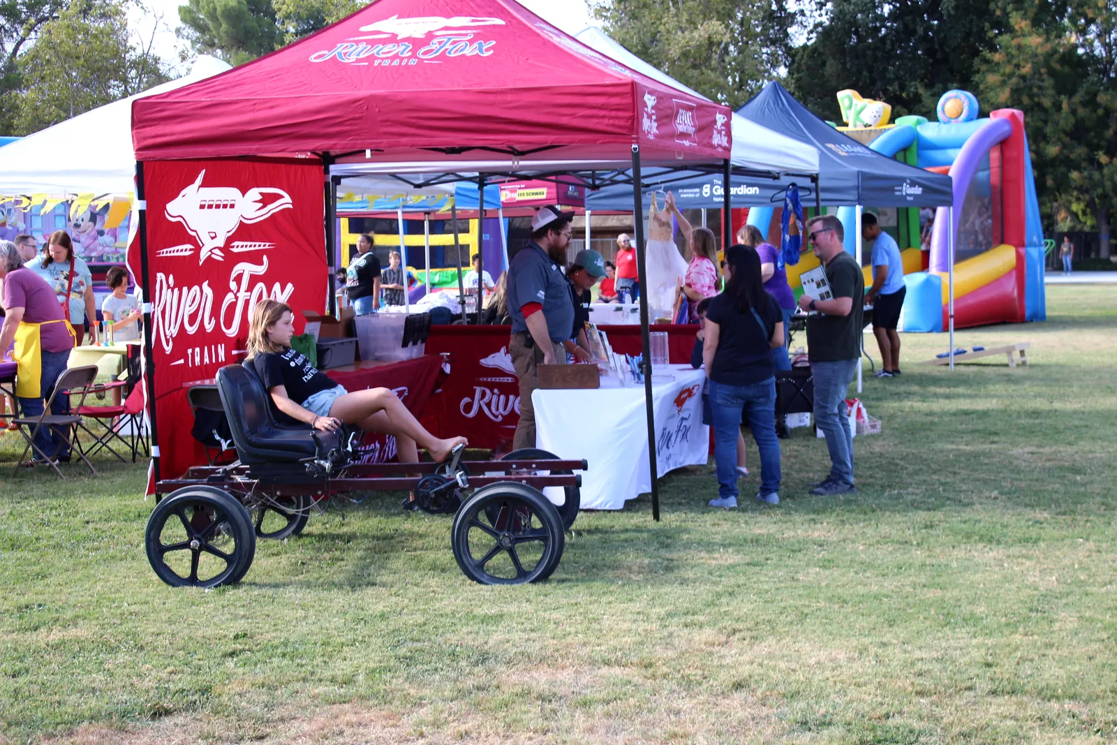 A red food vendor booth serves guests at the festival